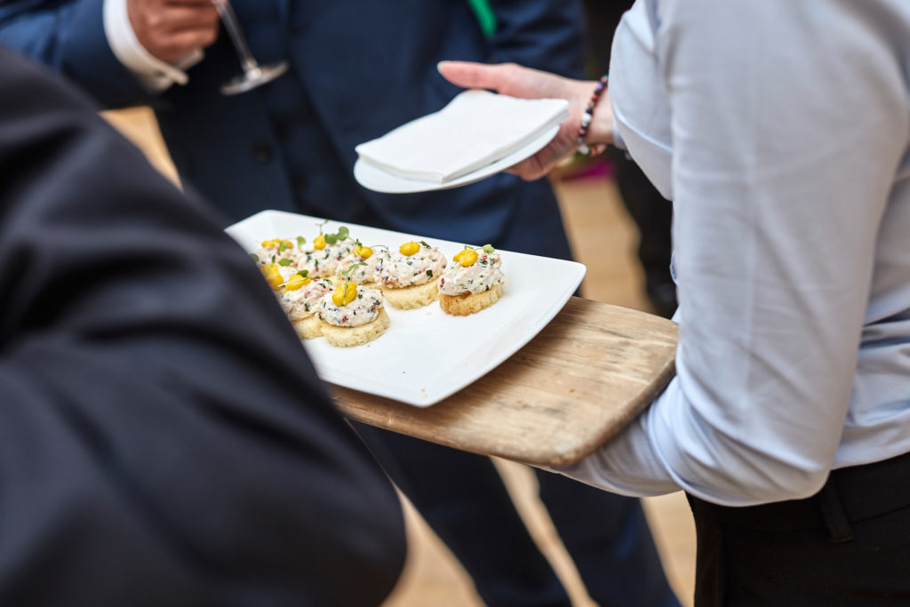 Waiter offering a tray of canapés to guests