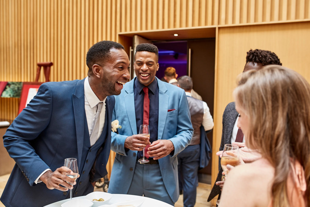 Groom laughing with guests at the drinks reception