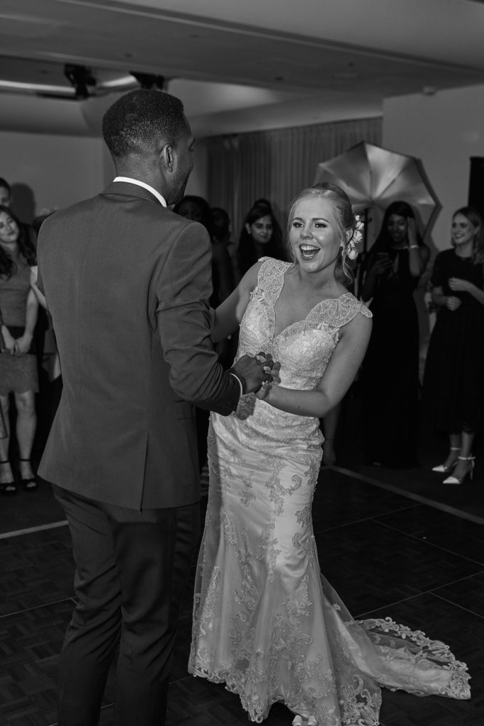 Black and white photo of the bride laughing during the first dance