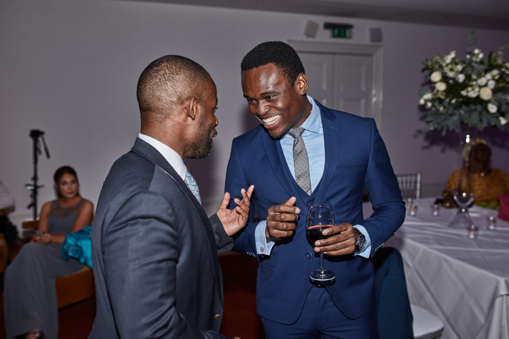 Two guests in suits laughing on the dance floor
