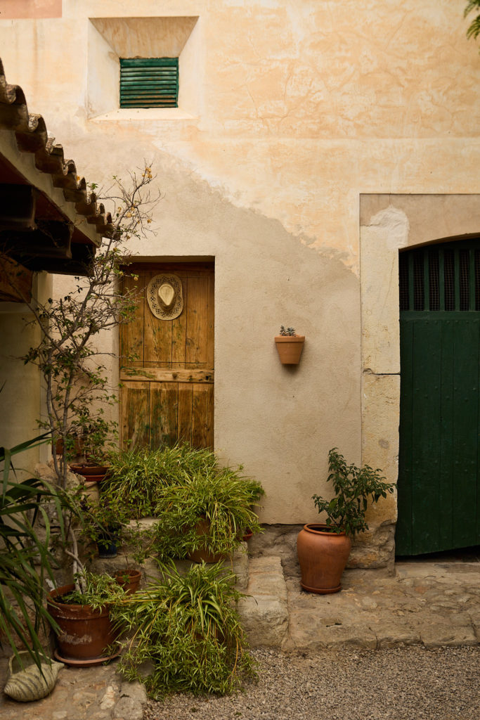 Wooden door and potted plants in the courtyard at Son Boronat