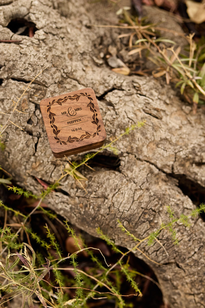 Engraved wooden ring box on a tree trunk