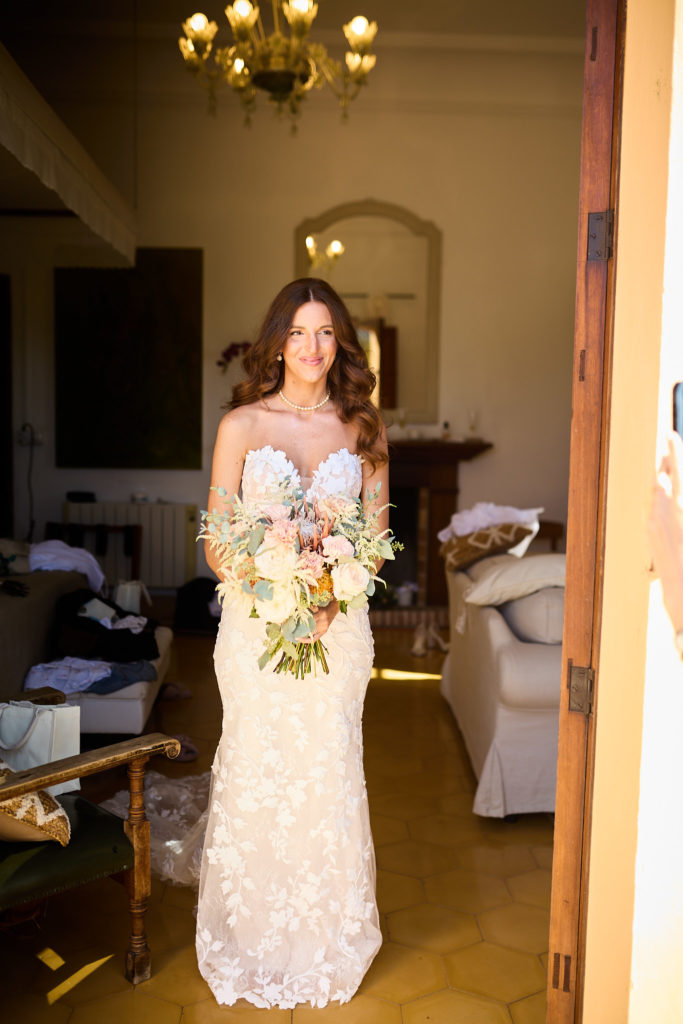 Bride in her lace wedding dress holding her bouquet in a doorway at Son Boronat