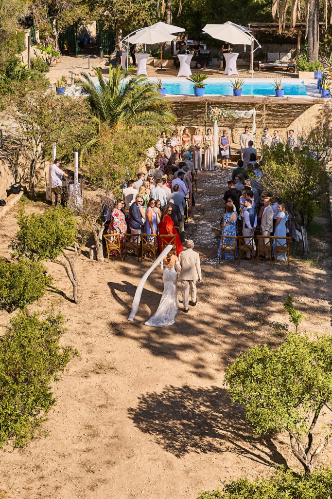 Bride walking down the aisle at her outdoor ceremony at Son Boronat, seen from above
