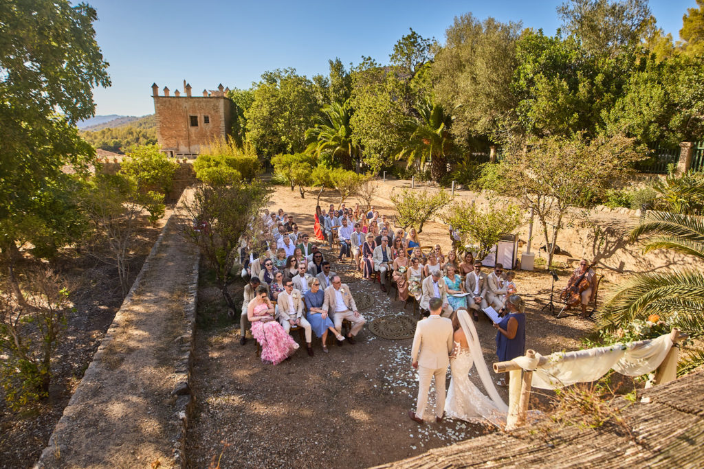 Wide view of the outdoor wedding ceremony among the trees at Son Boronat, Mallorca