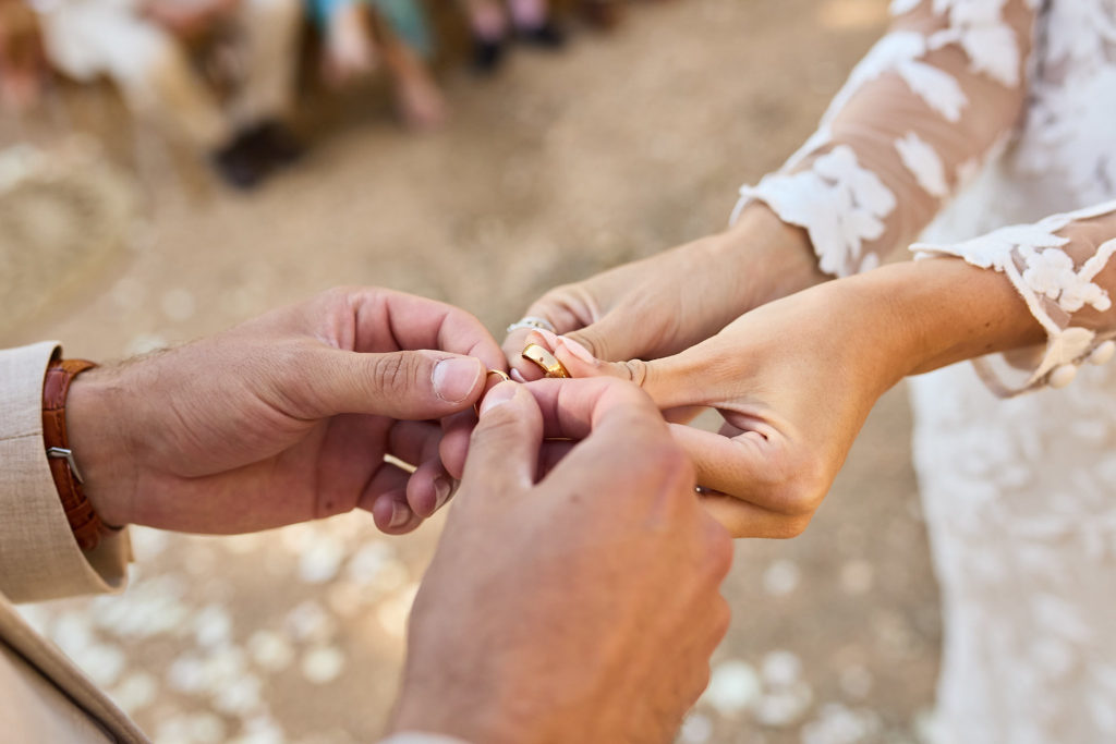 Close-up of the bride placing the wedding ring on the groom's finger