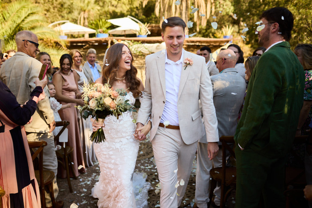 Bride and groom walking back down the aisle past their guests