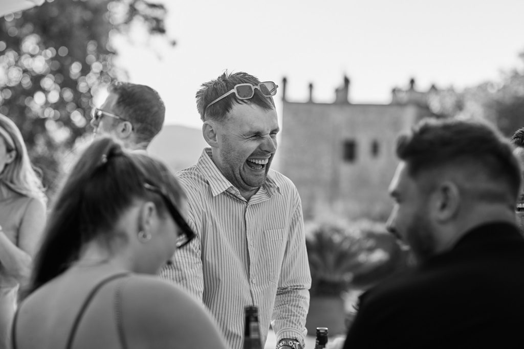 Black and white photo of wedding guests laughing together