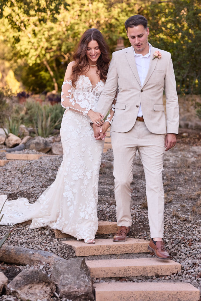 Bride and groom coming down the stone garden steps hand in hand at Son Boronat