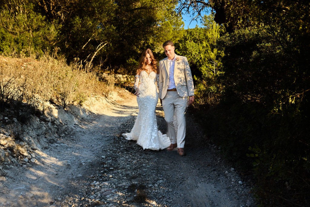 Bride and groom walking along a sunlit woodland track at Son Boronat