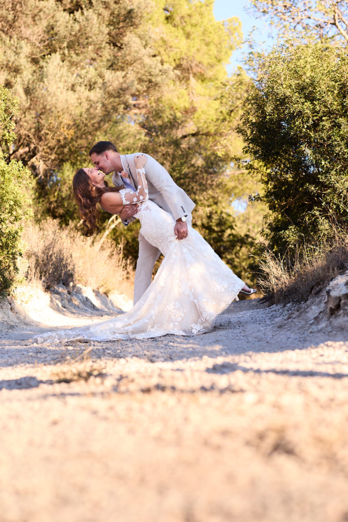 Groom dipping the bride for a kiss on a sandy track at Son Boronat