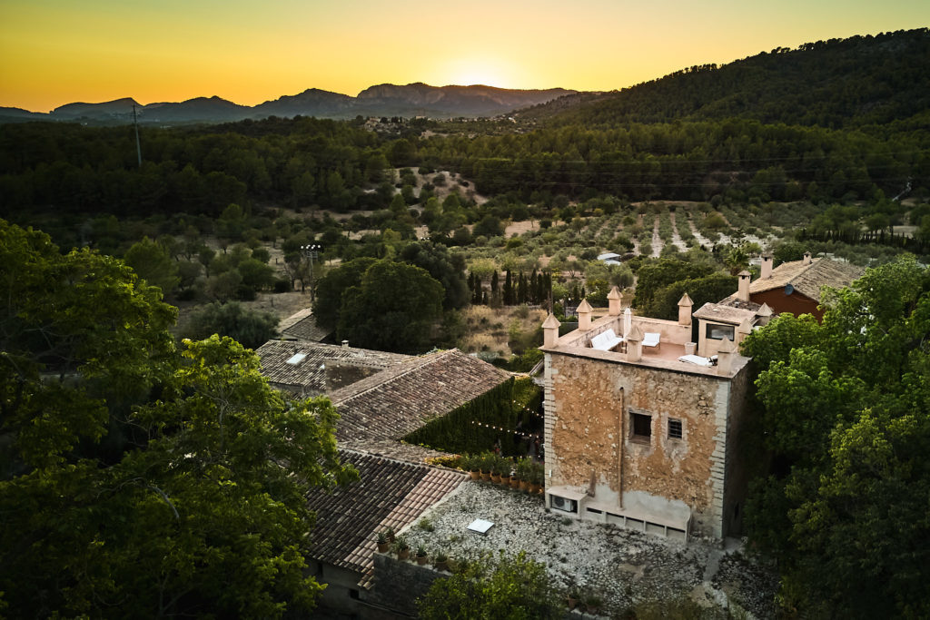 Aerial drone photo of the tower and rooftops of Son Boronat at sunset