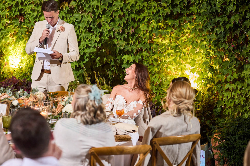 Groom giving his speech as the bride listens at the top table
