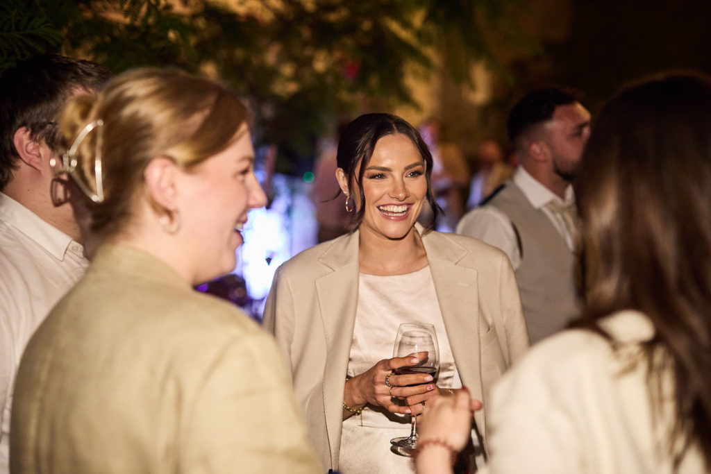 Bride laughing with guests in the evening