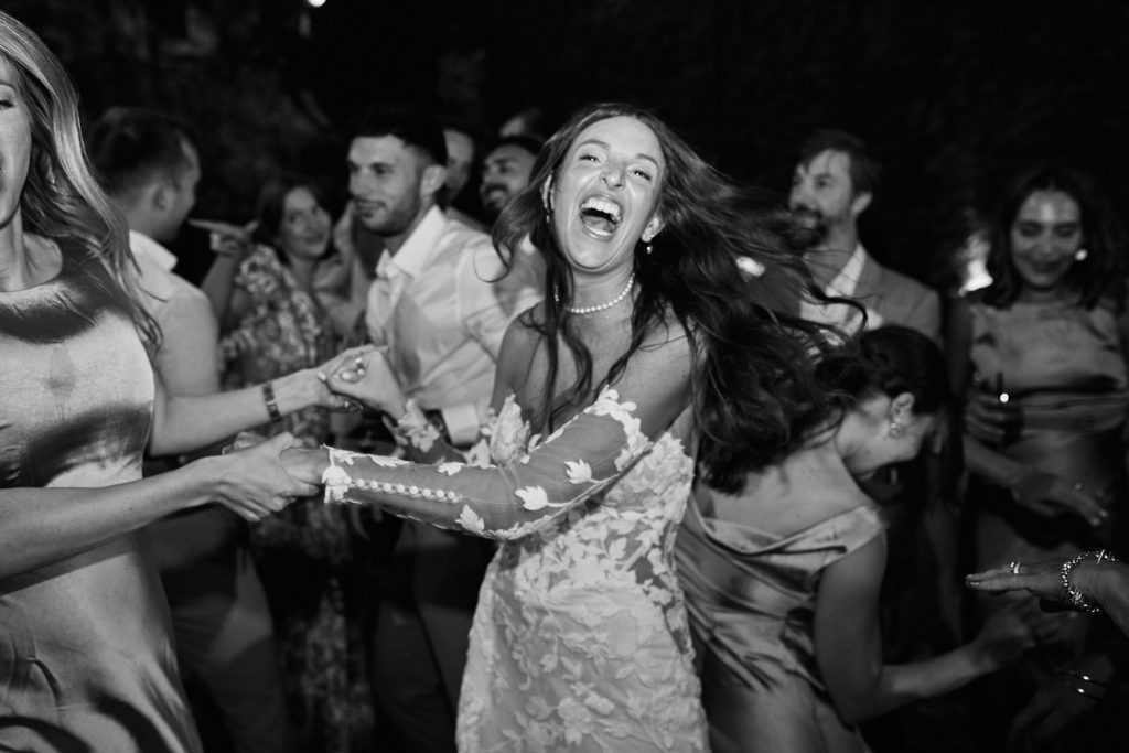 Black and white photo of the bride laughing on the dance floor