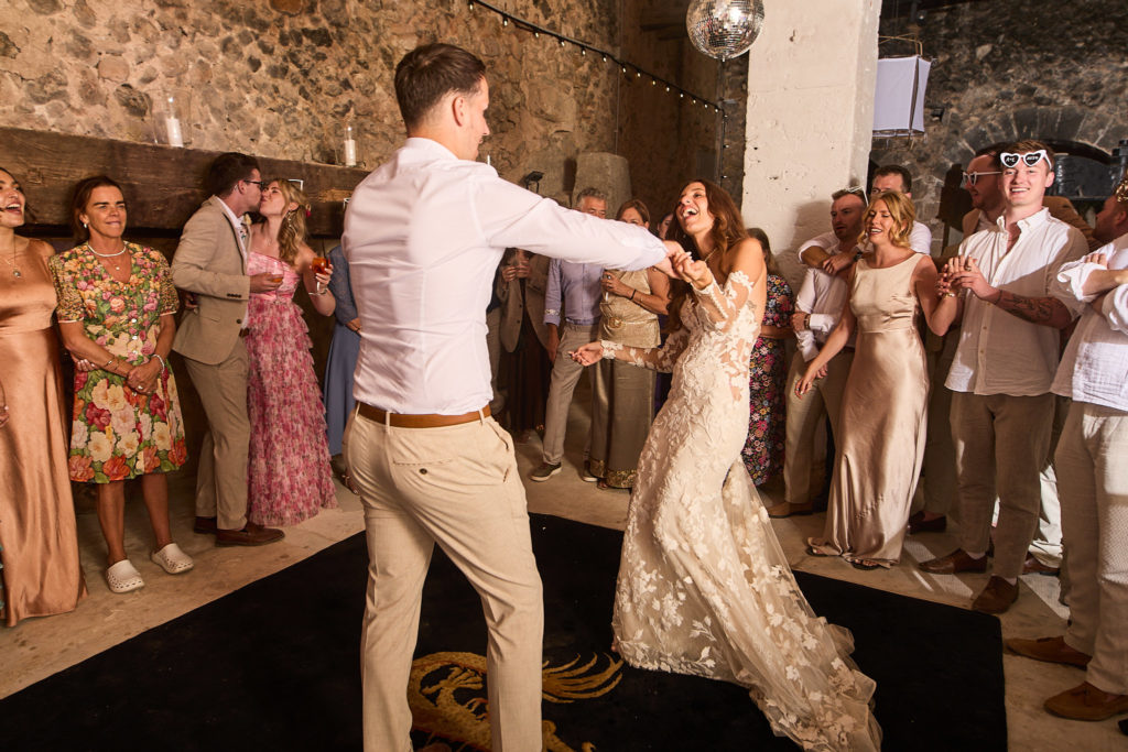 Bride and groom's first dance in the courtyard, watched by guests