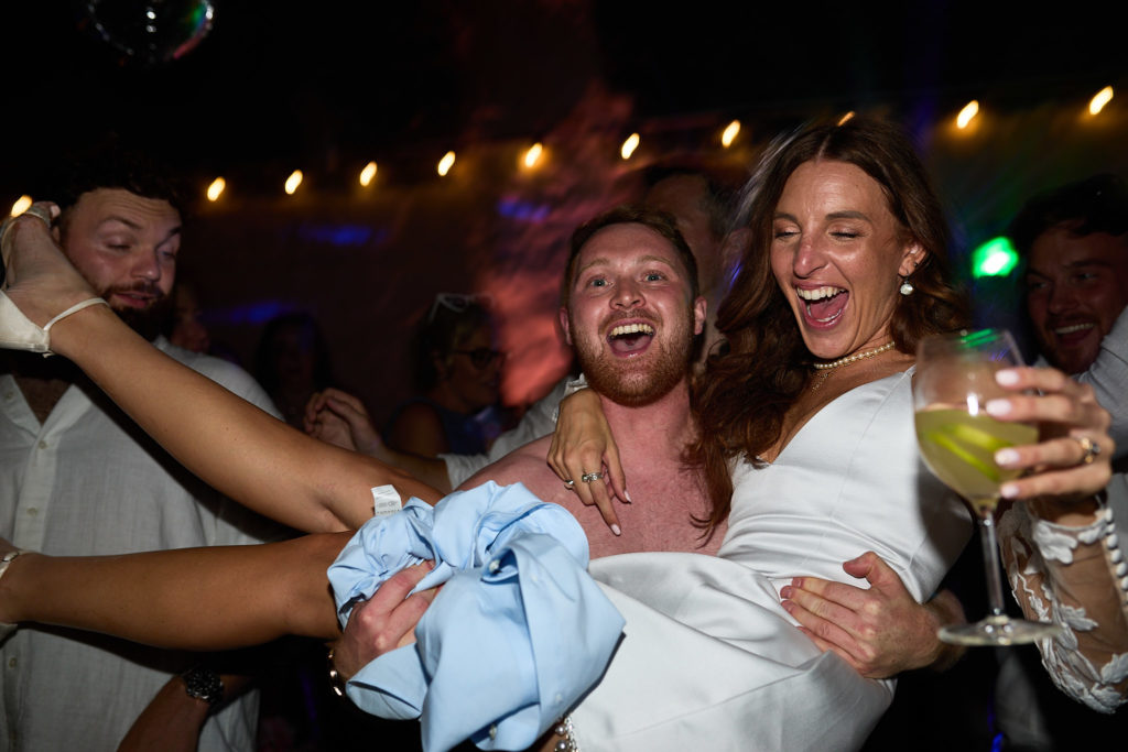 Bride laughing with guests on the dance floor