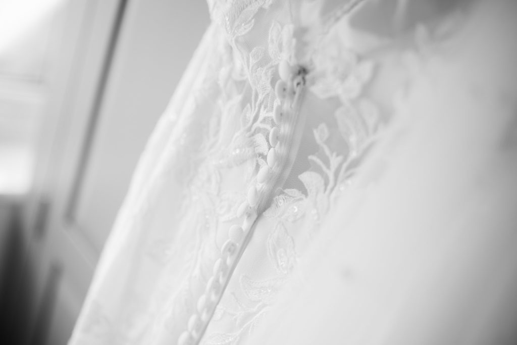 Black and white close-up of lace detail on the wedding dress