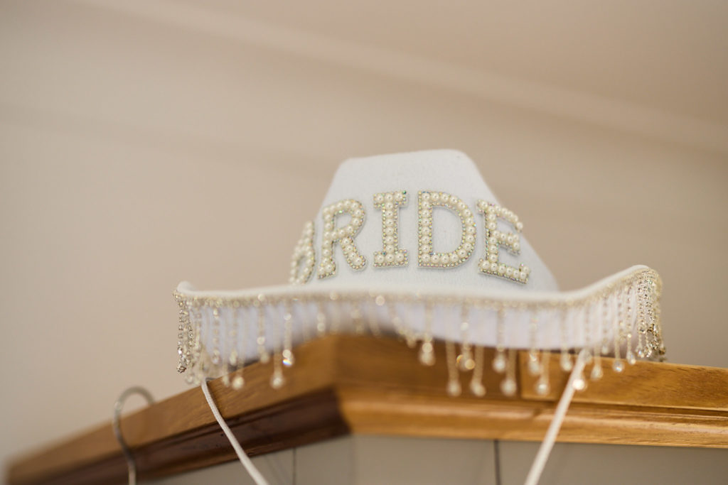 White cowboy hat with "Bride" spelled out in pearls