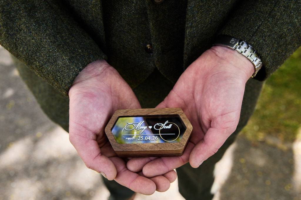 Hands holding a wooden wedding ring box