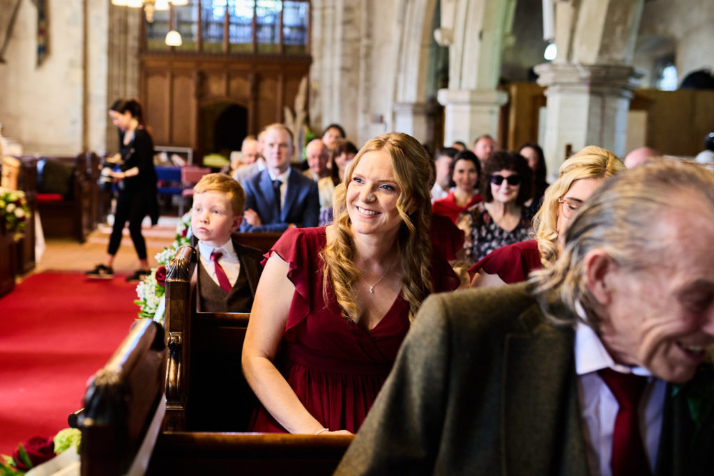Wedding guests laughing in the church pews