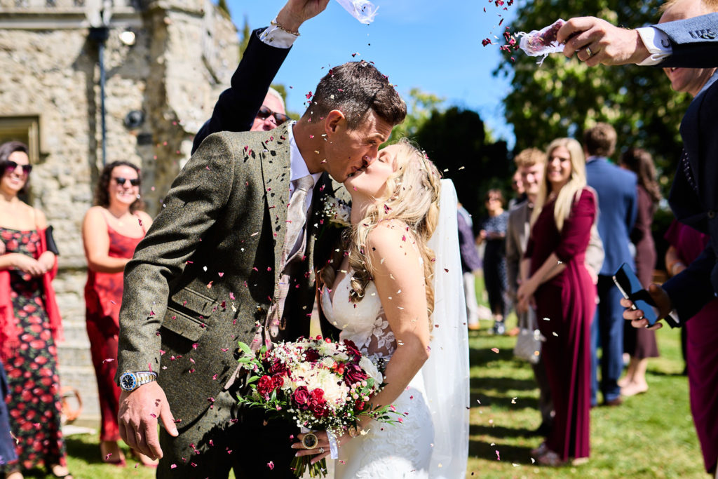 Groom kissing the bride in a shower of confetti