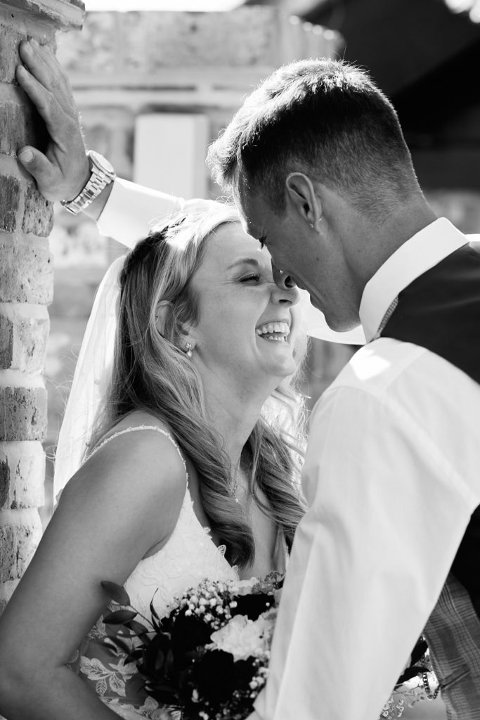 Black and white close-up of the bride laughing nose to nose with the groom