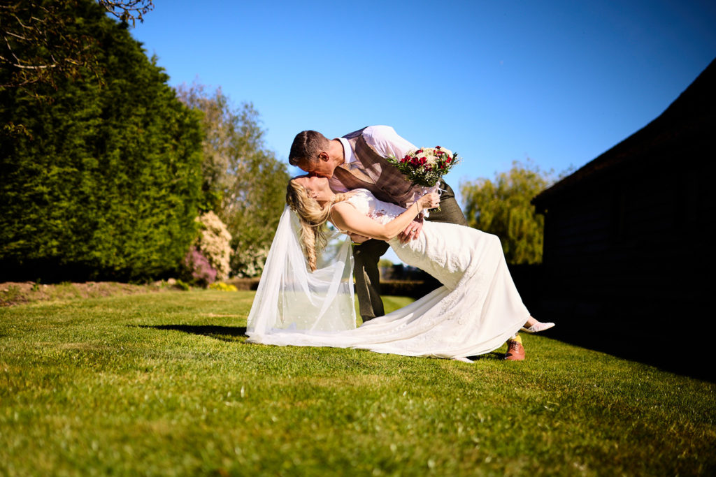 Groom dipping the bride low on the lawn