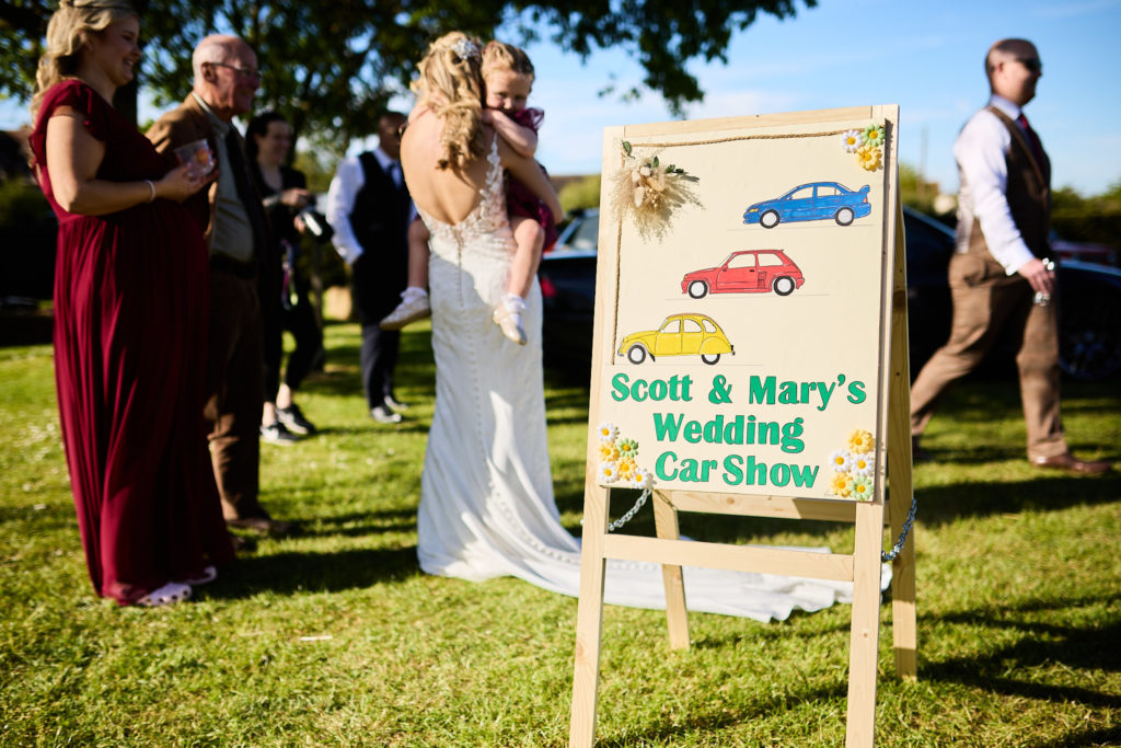 Hand-painted "Scott & Mary's Wedding Car Show" sign at the wedding reception in South Fambridge