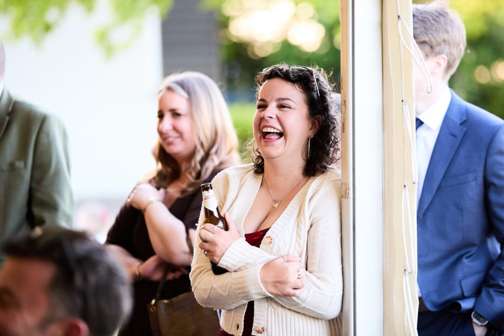Wedding guests laughing at the marquee entrance