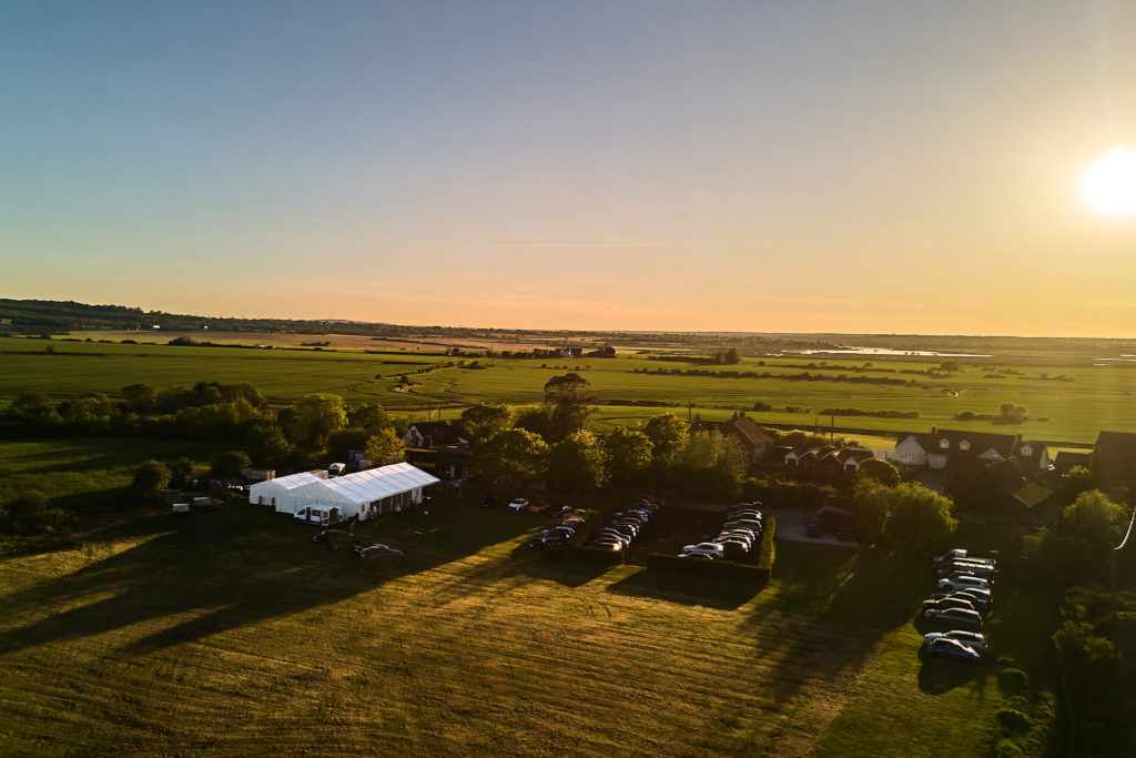 Aerial drone photo of the wedding marquee in fields at South Fambridge, near Rochford, Essex, at sunset