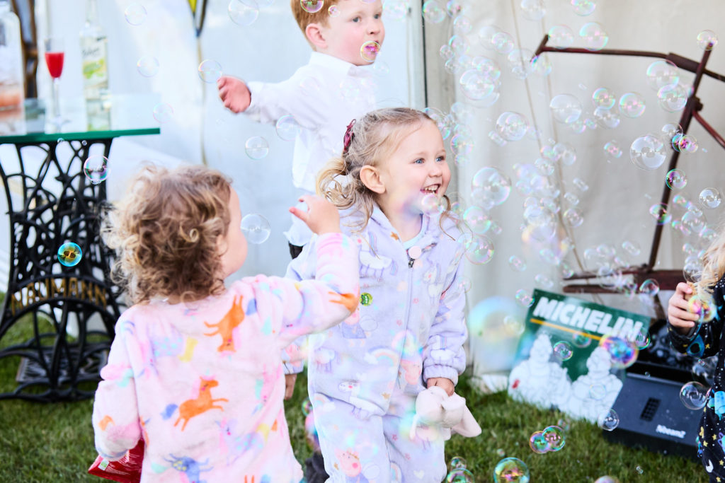 Children playing with bubbles outside the marquee