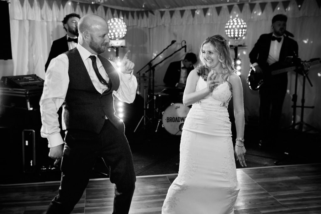 Black and white photo of the bride singing along with the band's singer
