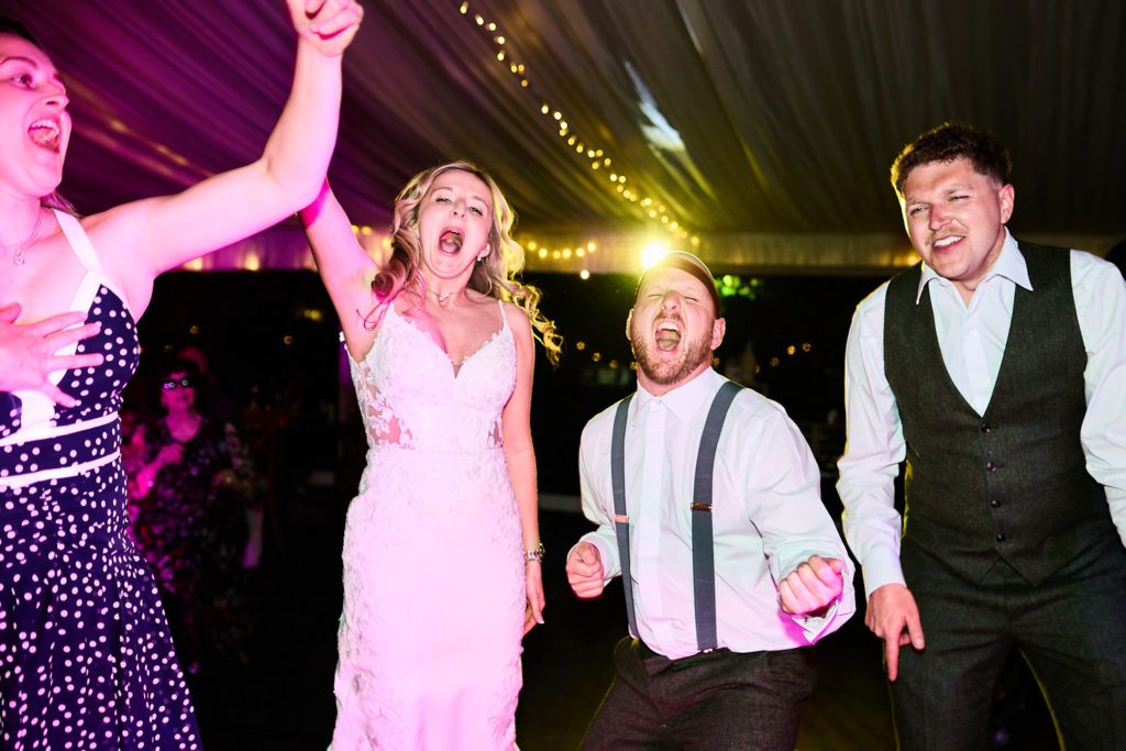 Bride and guests singing on the dance floor