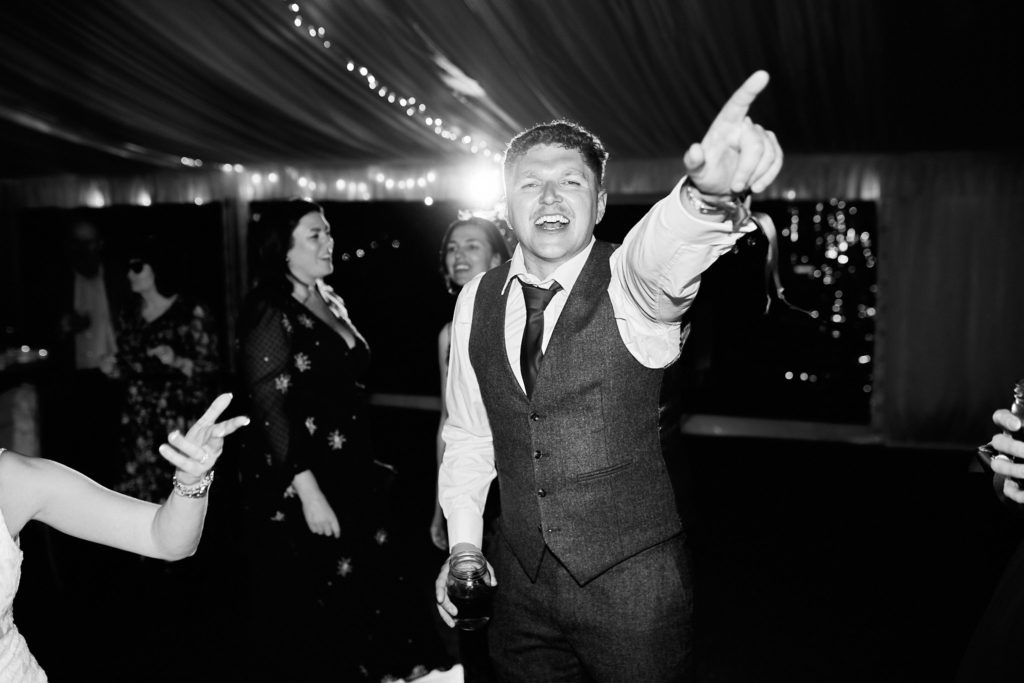 Black and white photo of a man in a waistcoat pointing on the dance floor