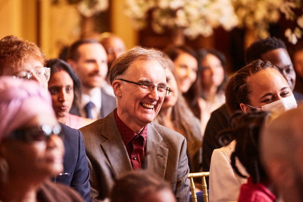 Wedding guests smiling as they watch the ceremony