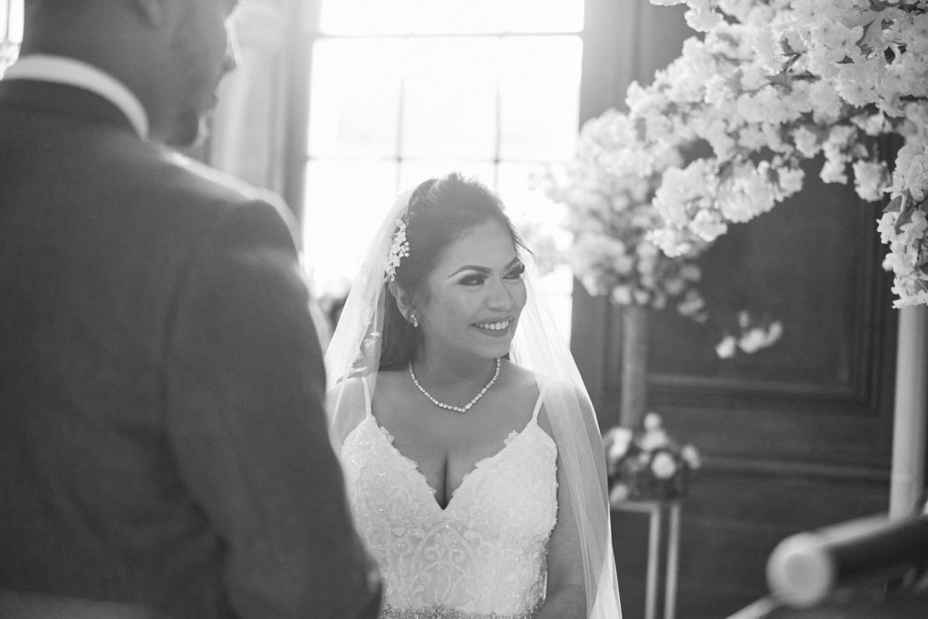 Black and white photo of the bride smiling as she arrives for the ceremony