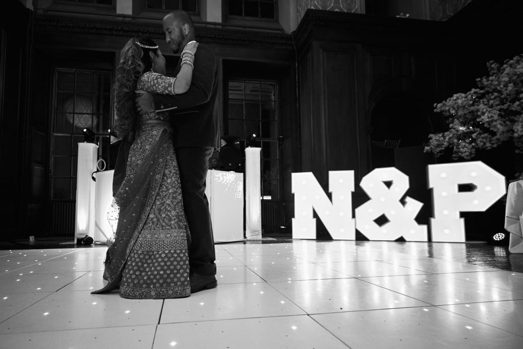 Black and white photo of the first dance in front of illuminated N and P letters