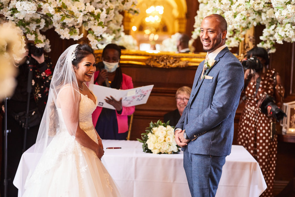 Bride and groom laughing during their wedding ceremony at Addington Palace, Surrey