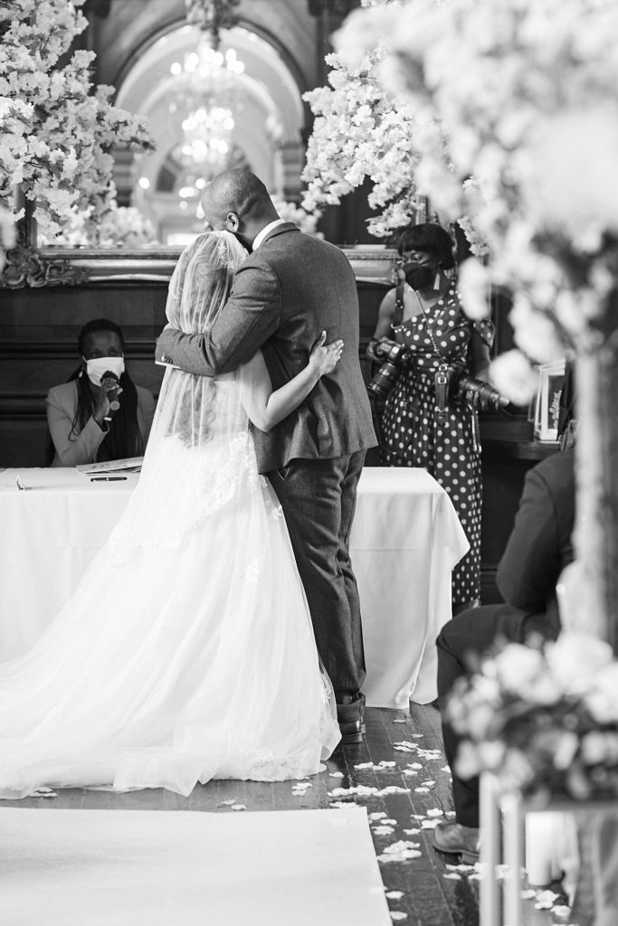 Black and white photo of the bride and groom embracing after their vows