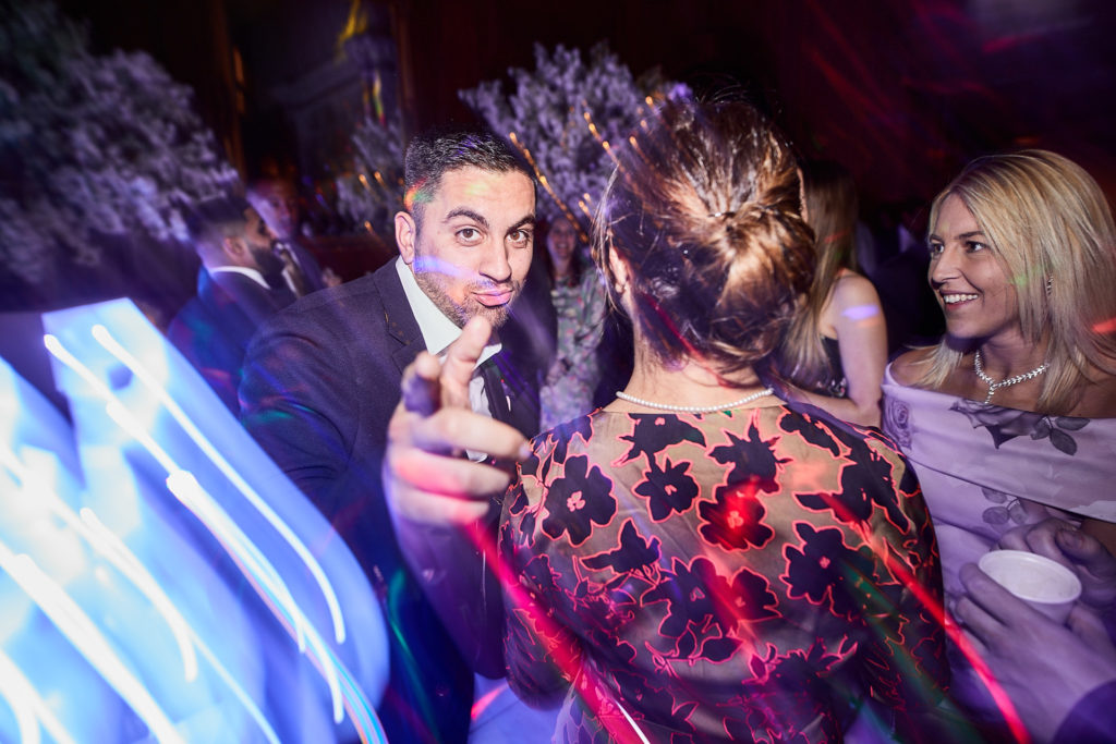 Wedding guests dancing under blue lights