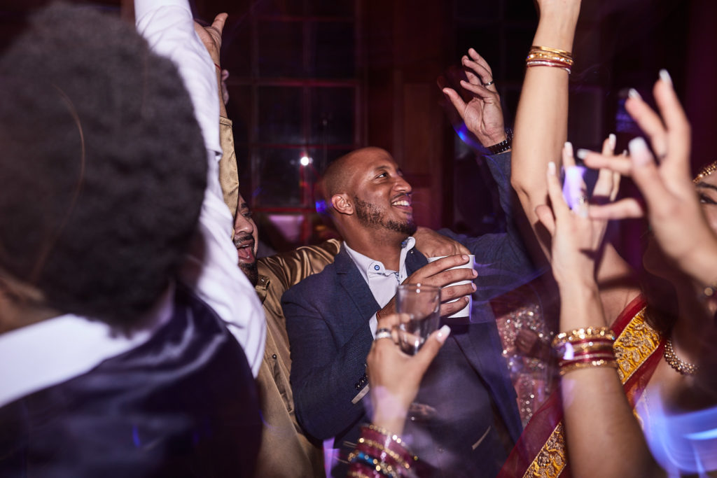 Wedding guests dancing with their hands in the air