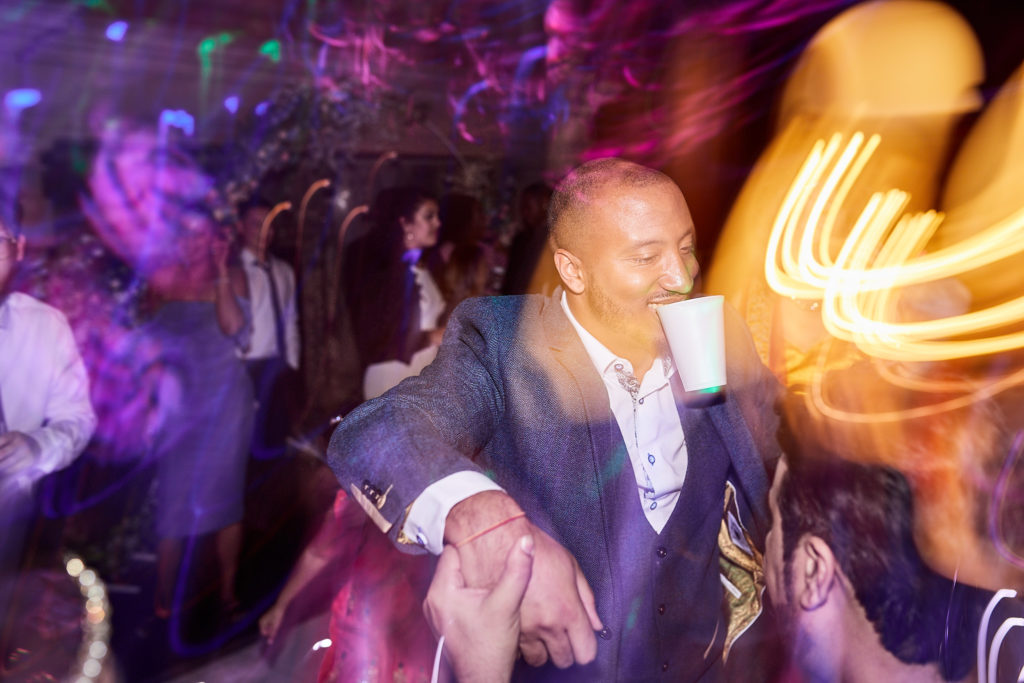 Groom dancing among streaks of golden light