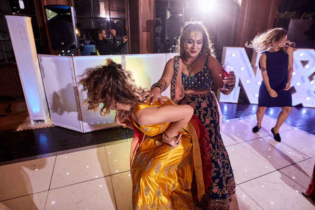 Bridesmaid in a yellow lehenga dancing on the light-up dance floor