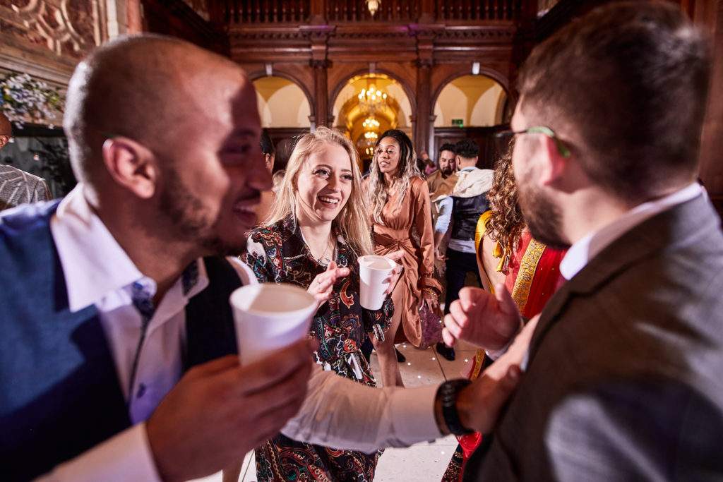Wedding guests laughing together with drinks