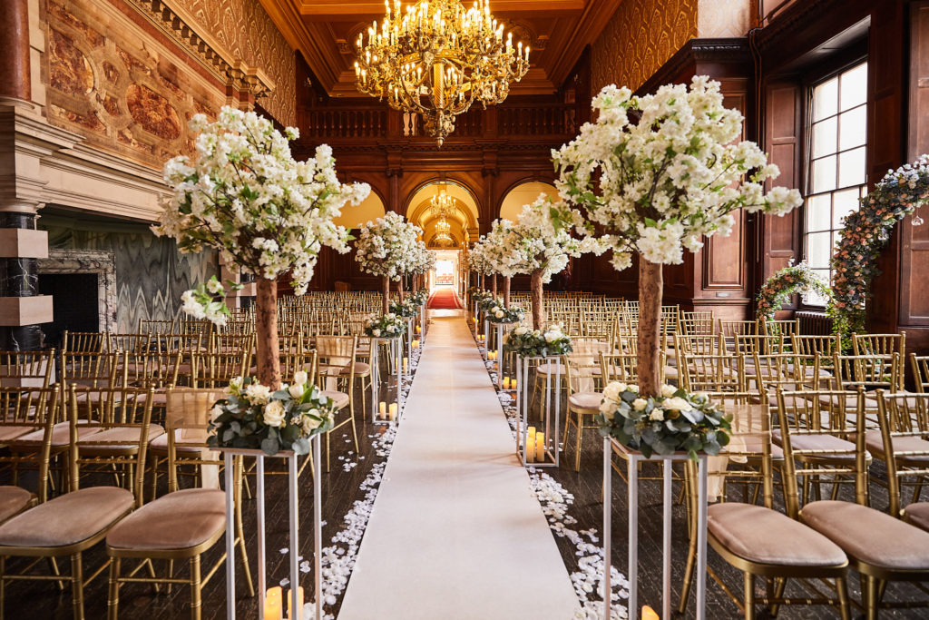 The Great Hall at Addington Palace set for the ceremony with a white aisle and blossom trees