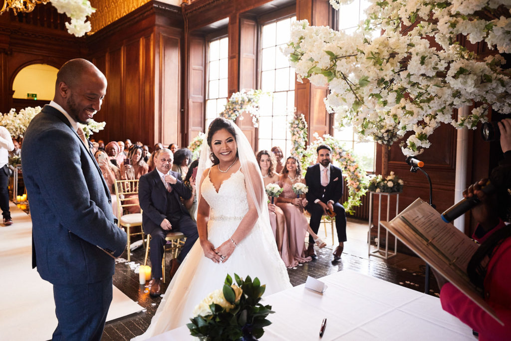 Bride smiling as she joins the groom at the front of the ceremony