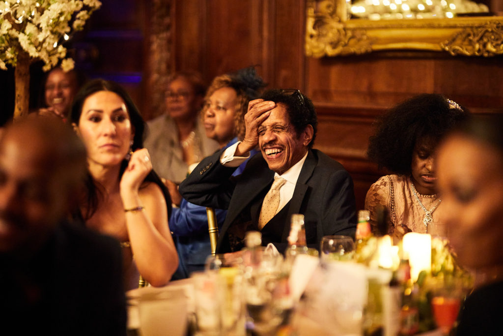 Wedding guests laughing at their table during the speeches