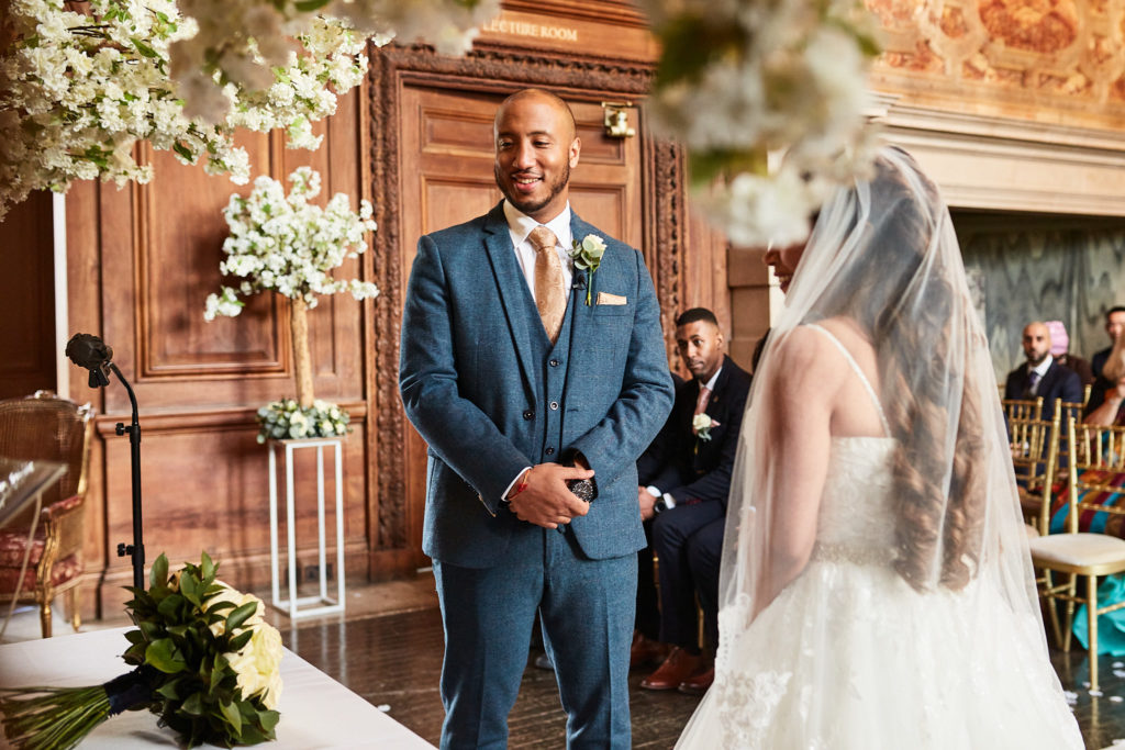 Groom watching as the bride arrives beside him in her veil