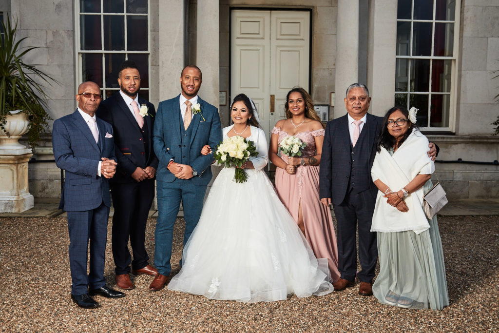 Bride and groom with their family outside Addington Palace